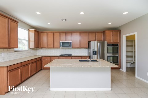 A kitchen with brown cabinets and a white island.