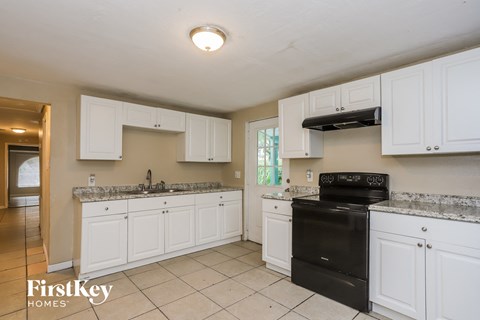 A kitchen with white cabinets and a black oven.