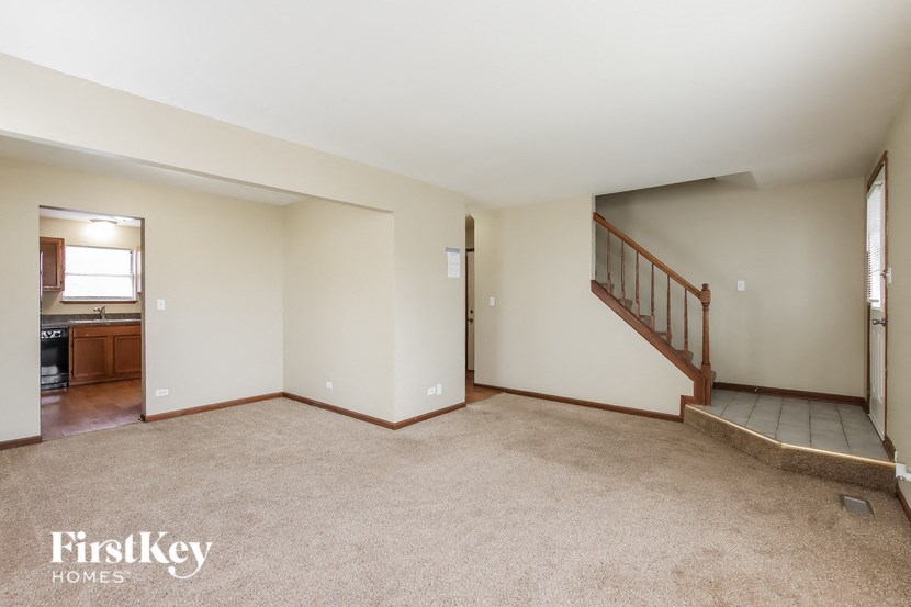 A spacious room with a staircase leading to another level.