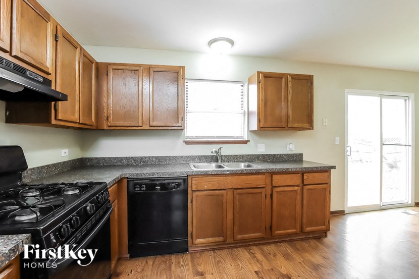 A kitchen with wooden cabinets and a black stove top oven.