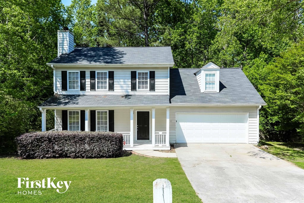 a white house with a gray roof and a white garage