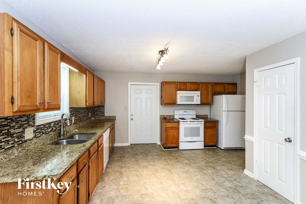 a kitchen with wooden cabinets and white appliances