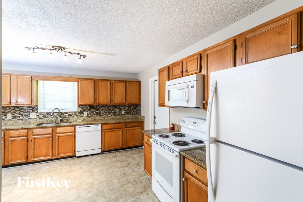 a kitchen with white appliances and wooden cabinets