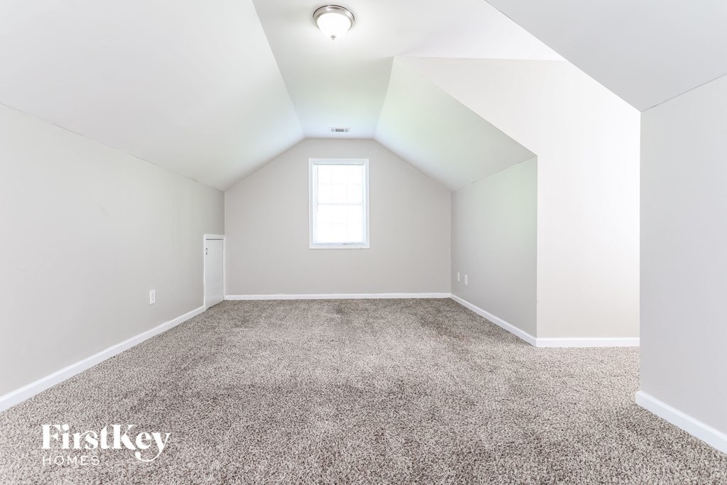 a empty room with carpet and a window