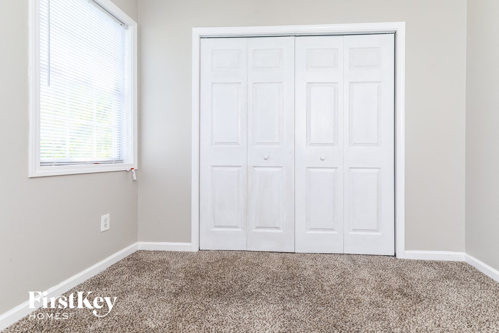 a bedroom with two closets and a carpeted floor