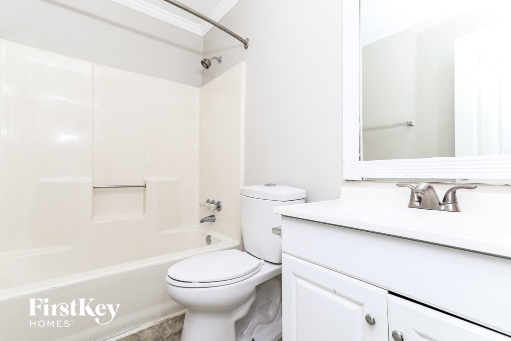 a white bathroom with a white toilet and a tub and a sink