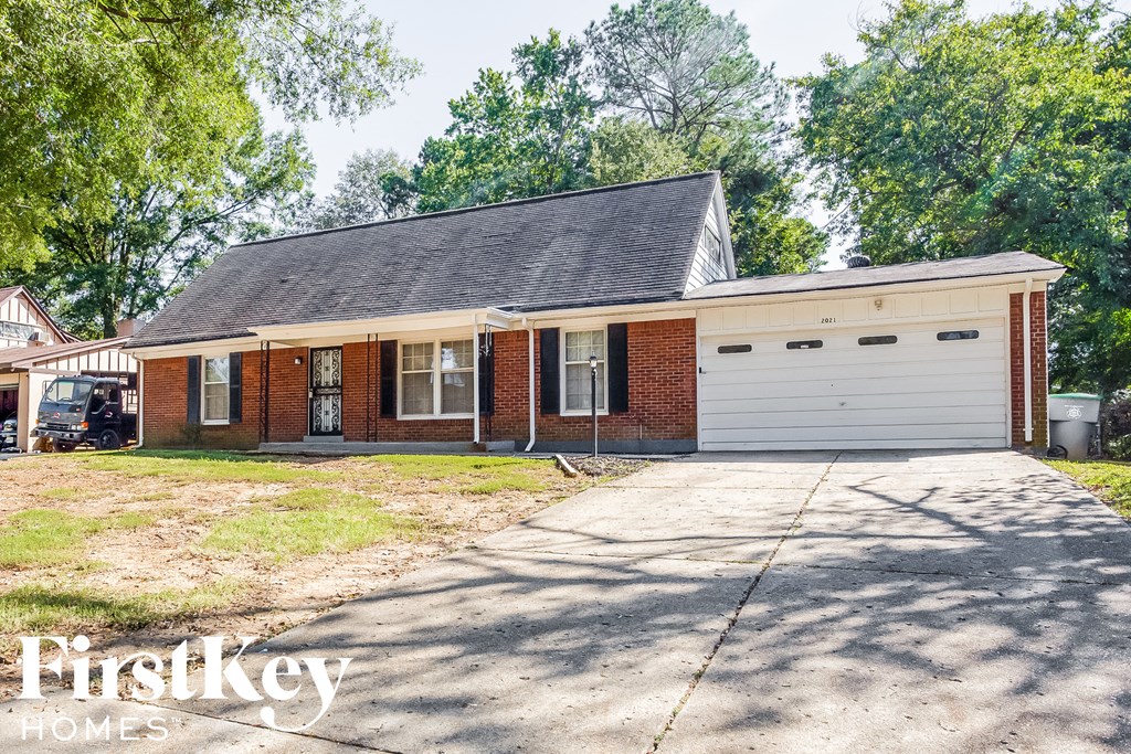 A two-car garage is attached to a brick house.