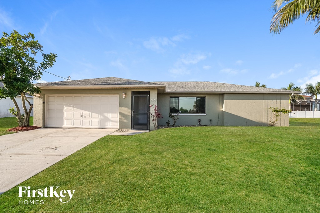 a beige house with a lawn and a garage door