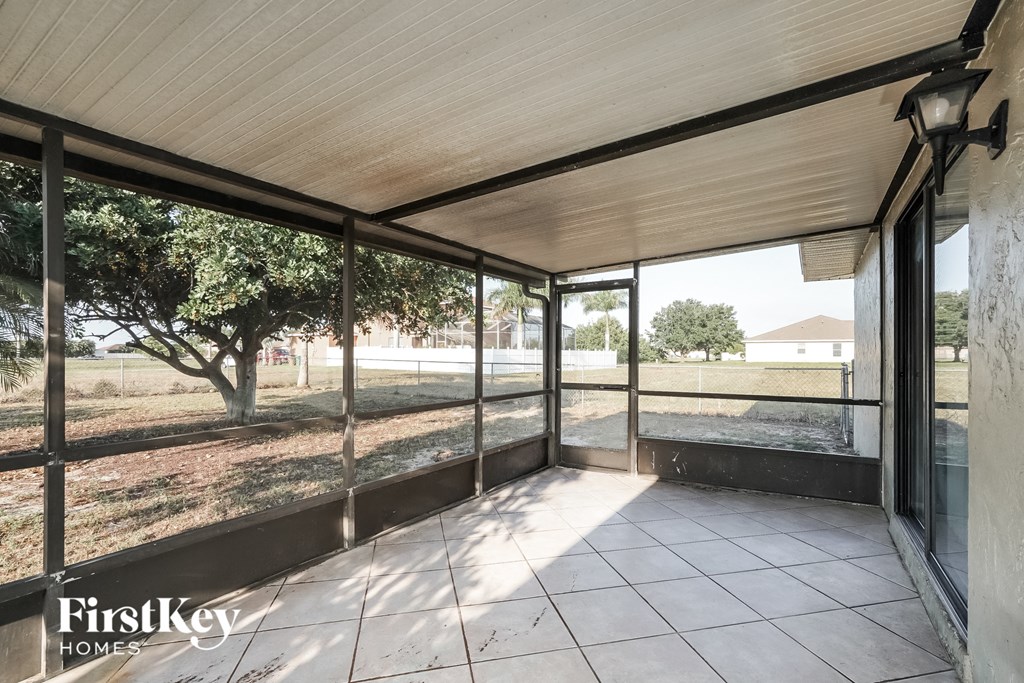 the screened porch has a view of the yard and the grass