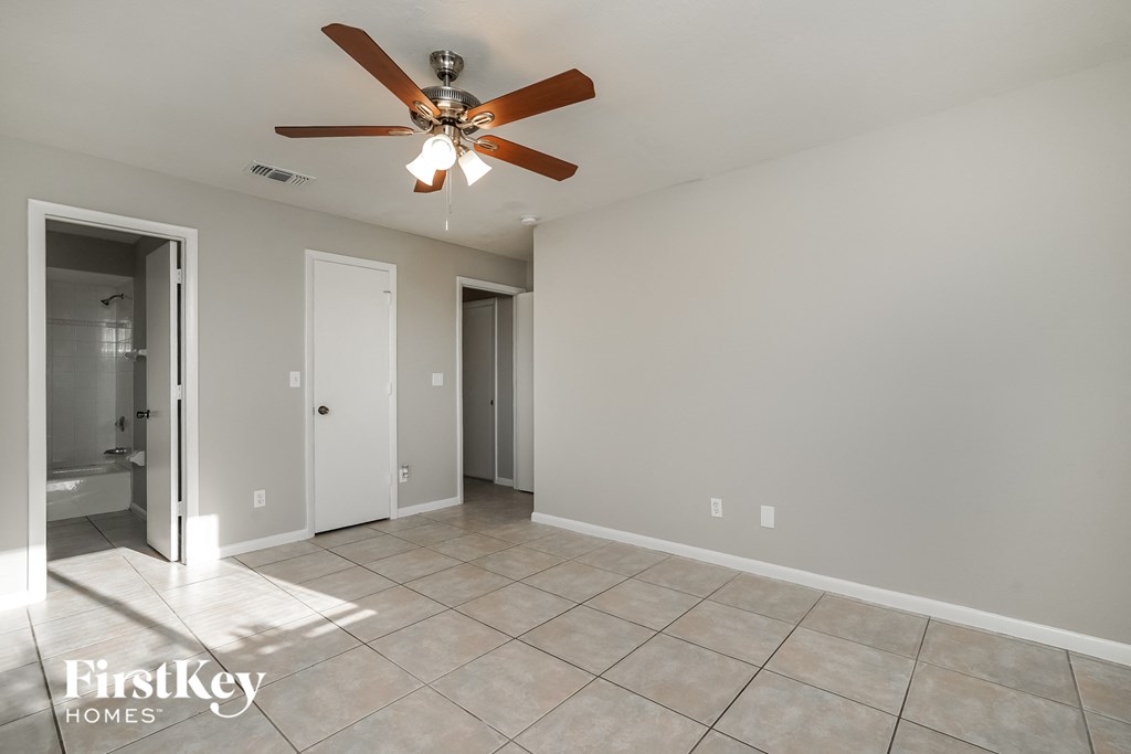 a living room with a ceiling fan and a tiled floor