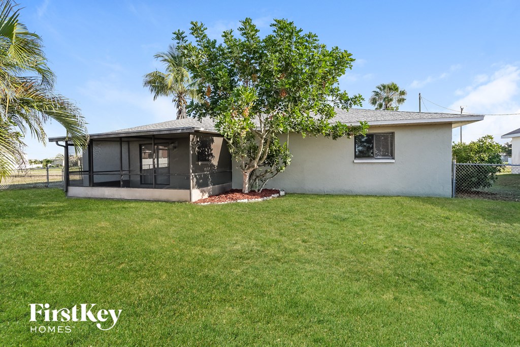 a small white house with a tree in the yard