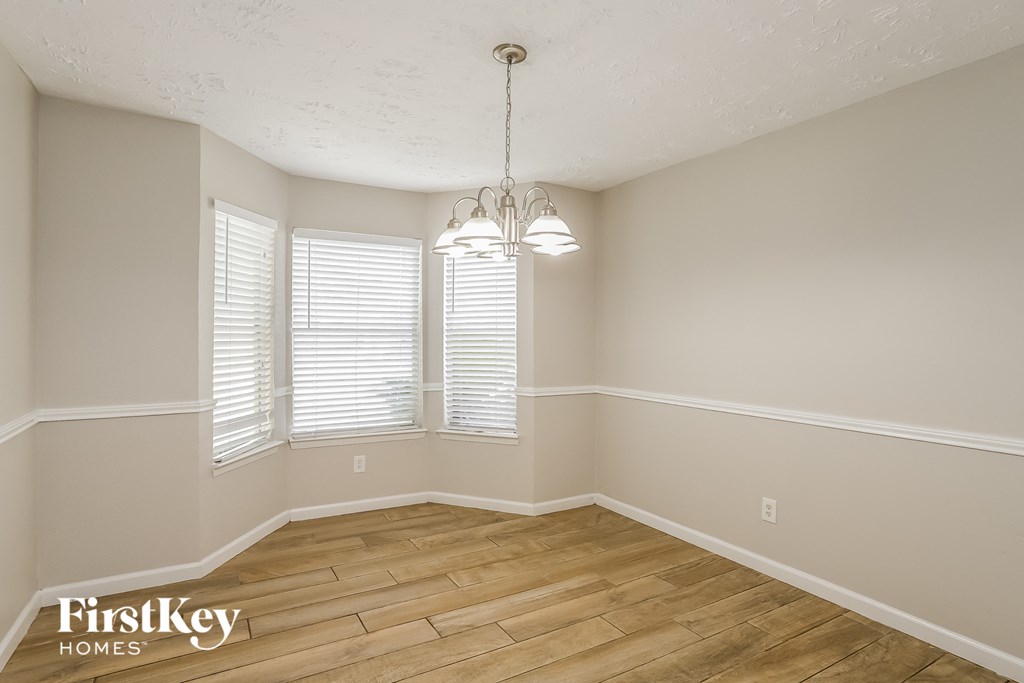 the spacious dining room with hardwood flooring and windows