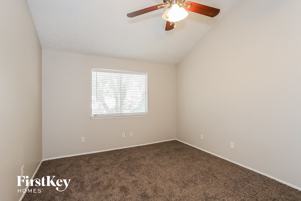 a bedroom with carpet and a ceiling fan