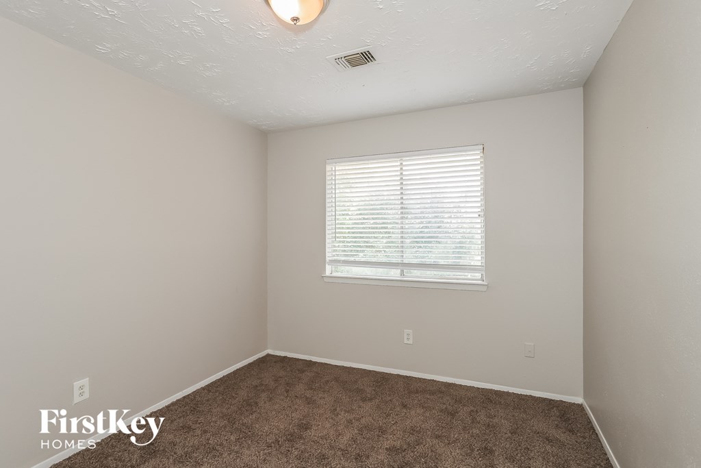 a bedroom with a carpeted floor and a window