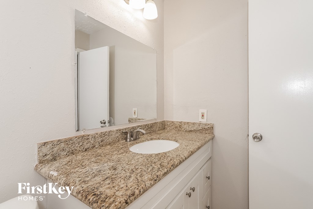 a bathroom with a granite counter top and a sink