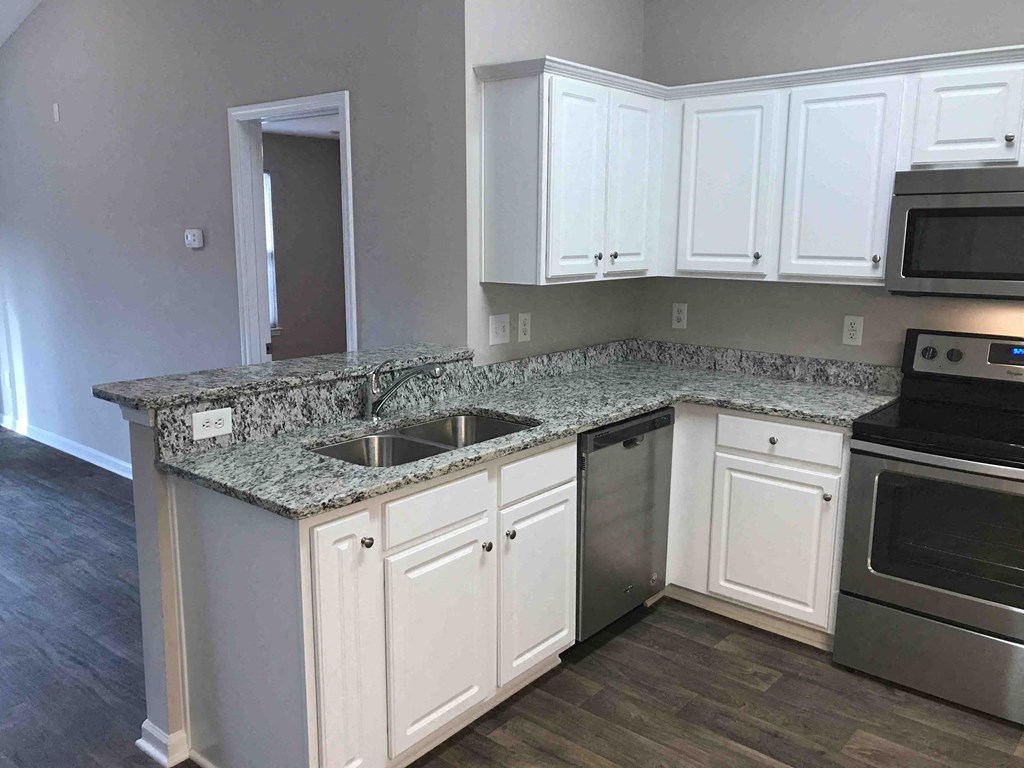 A kitchen with granite countertops and stainless steel appliances.