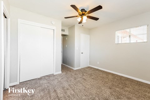 a bedroom with a ceiling fan and a closet