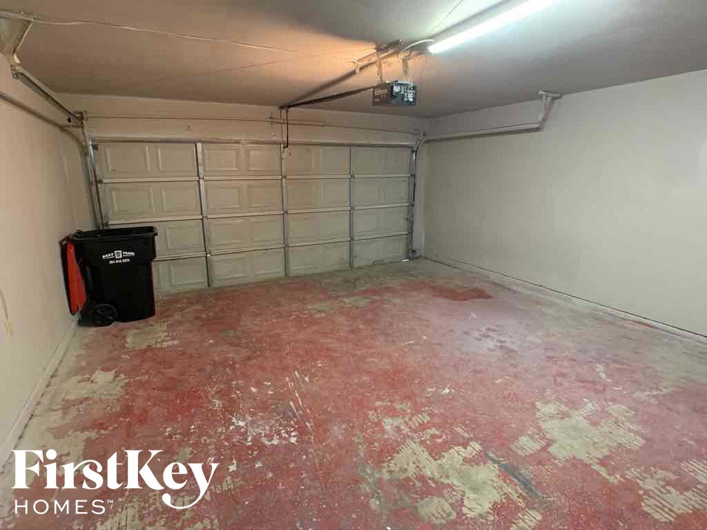 A garage with a red floor and a black toolbox.
