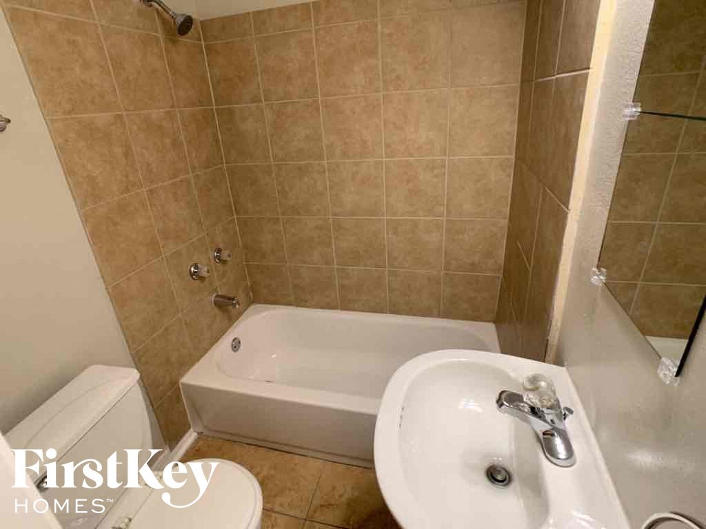 A bathroom with a tub, toilet, and sink.