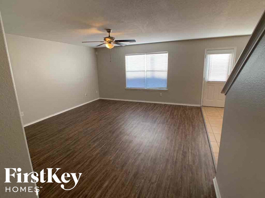 A room with wooden flooring and a ceiling fan.