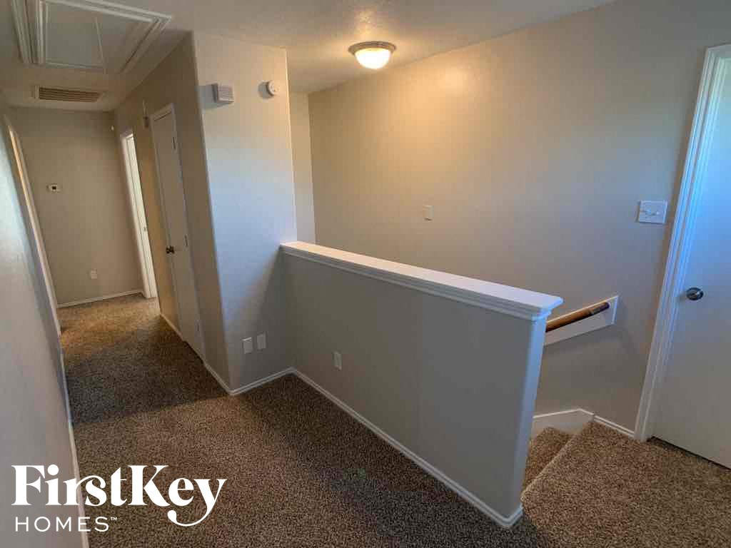 A hallway with a bench and a carpeted floor.