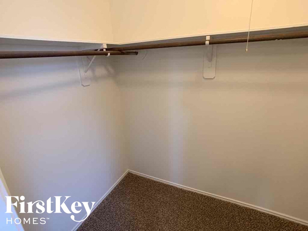 A corner of a room with a brown carpet and white walls.