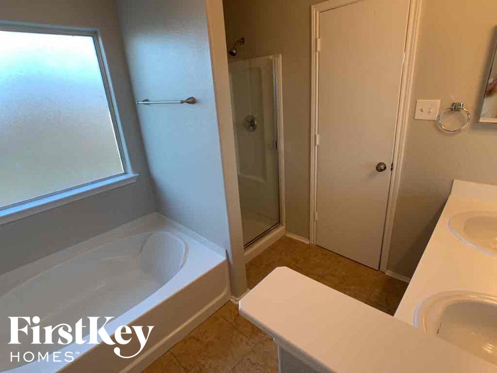 A bathroom with a tub, toilet, and sink.