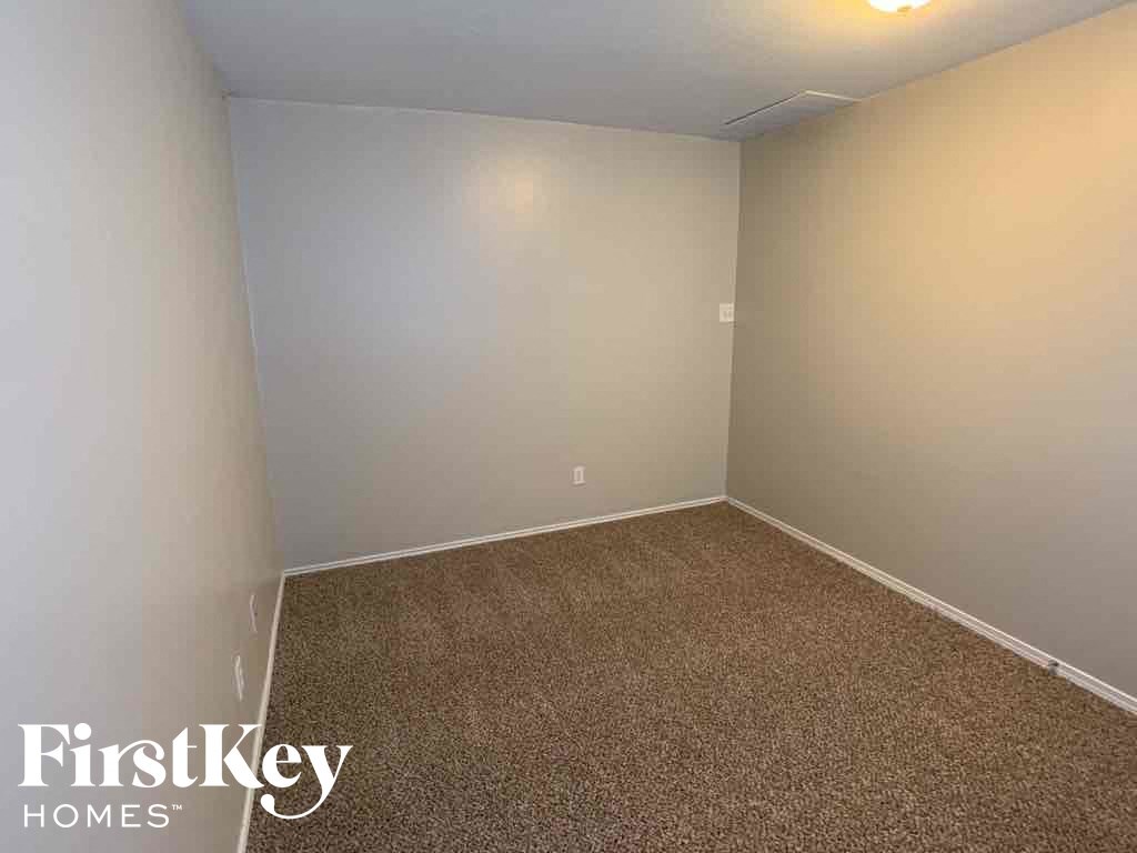 A carpeted room with a FirstKey Homes logo.