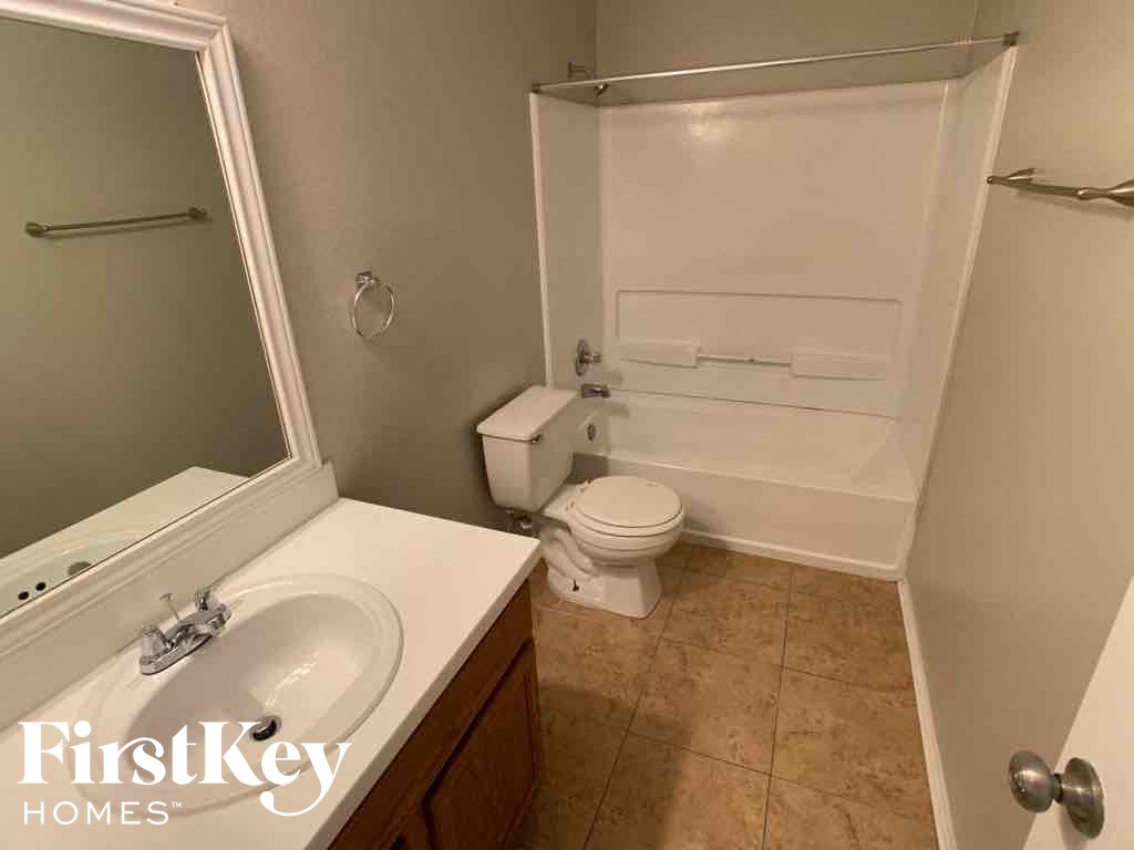 A bathroom with a toilet, sink, and bathtub.