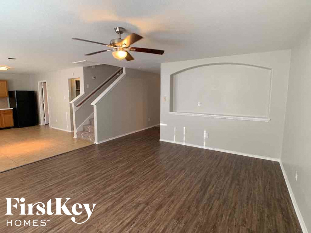 A room with wooden flooring and a ceiling fan.