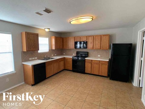 A kitchen with wooden cabinets and black appliances.