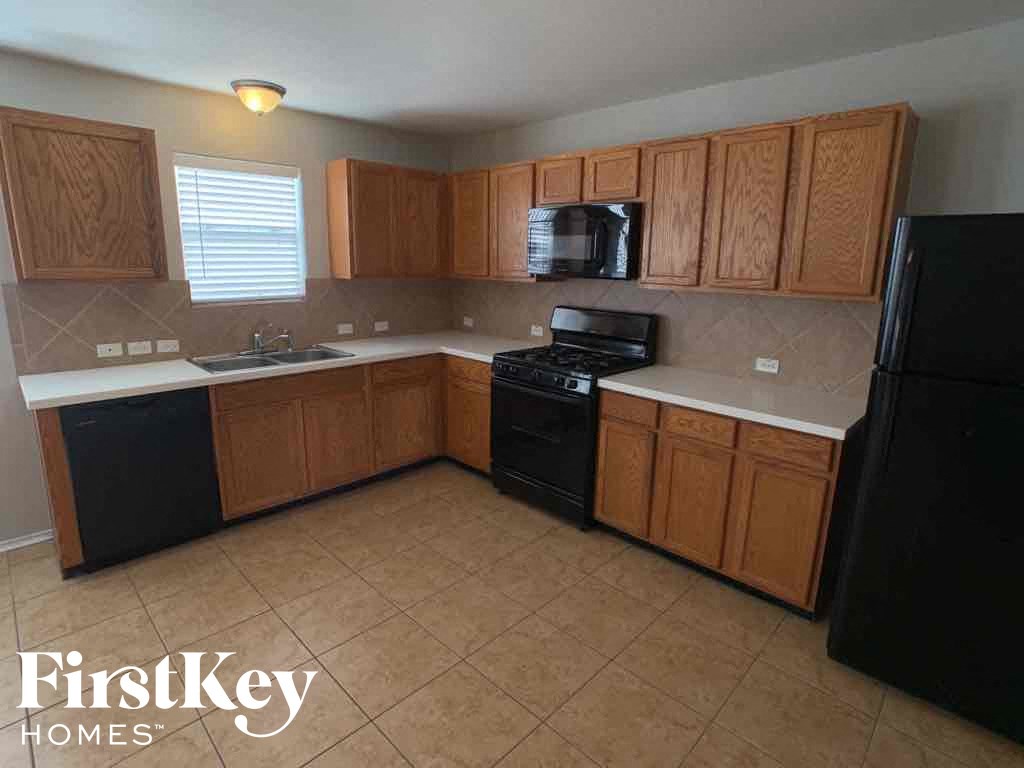 A kitchen with black appliances and wooden cabinets.
