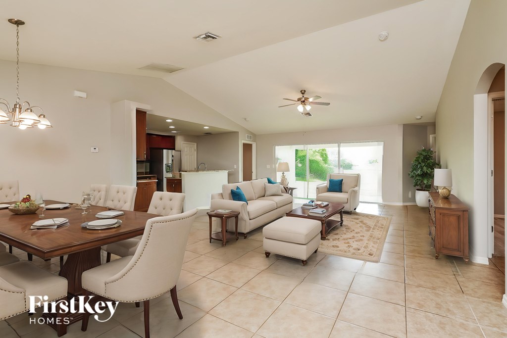 A spacious dining room with a wooden table and chairs.