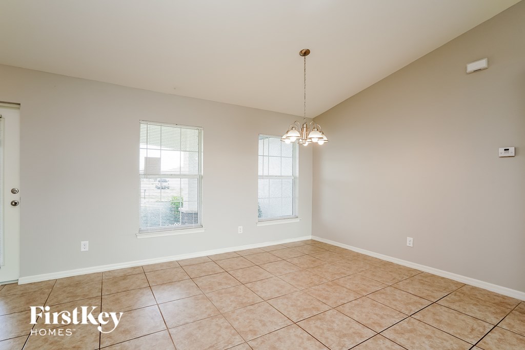 A room with a tile floor and a chandelier hanging from the ceiling.