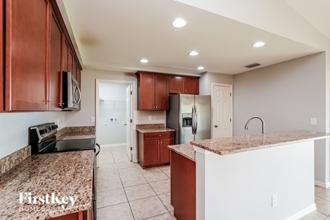 A kitchen with brown cabinets and a granite countertop.