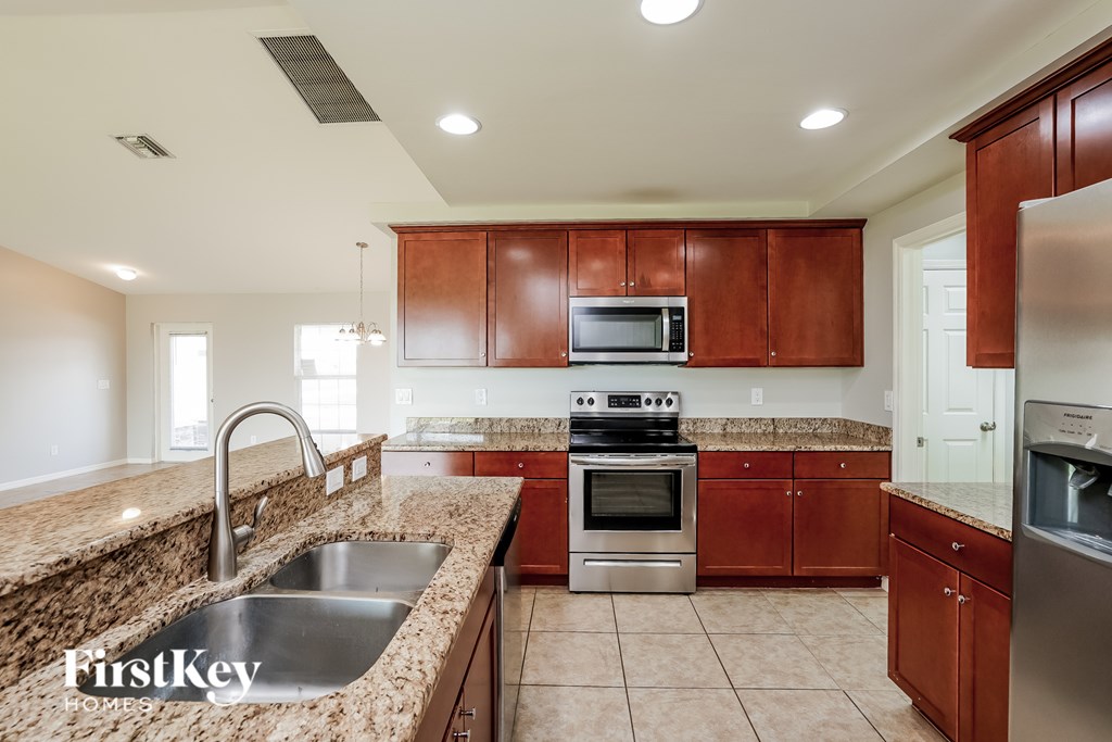 A kitchen with brown cabinets and a stainless steel refrigerator.