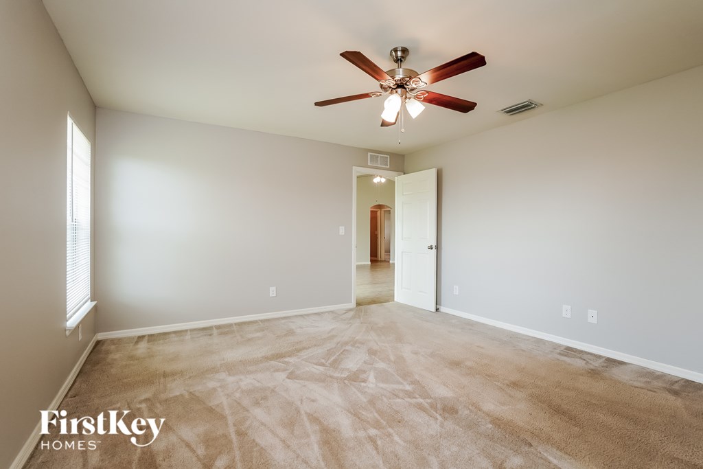 A room with a ceiling fan and a door.