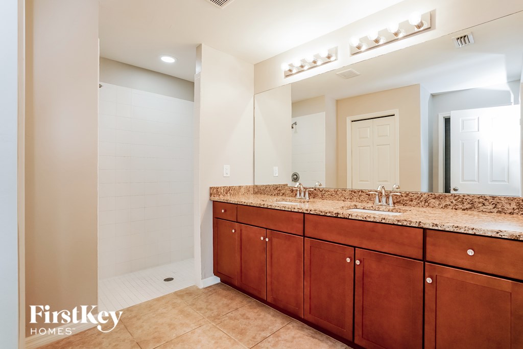 A bathroom with a vanity and a large mirror.