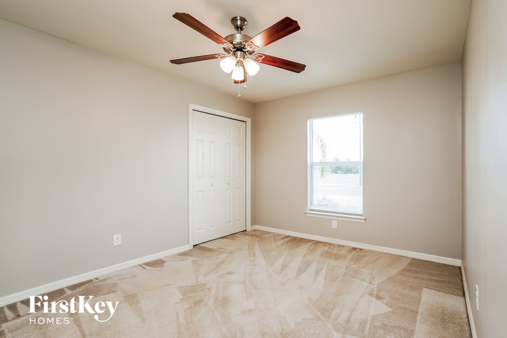 A room with a fan and a window.