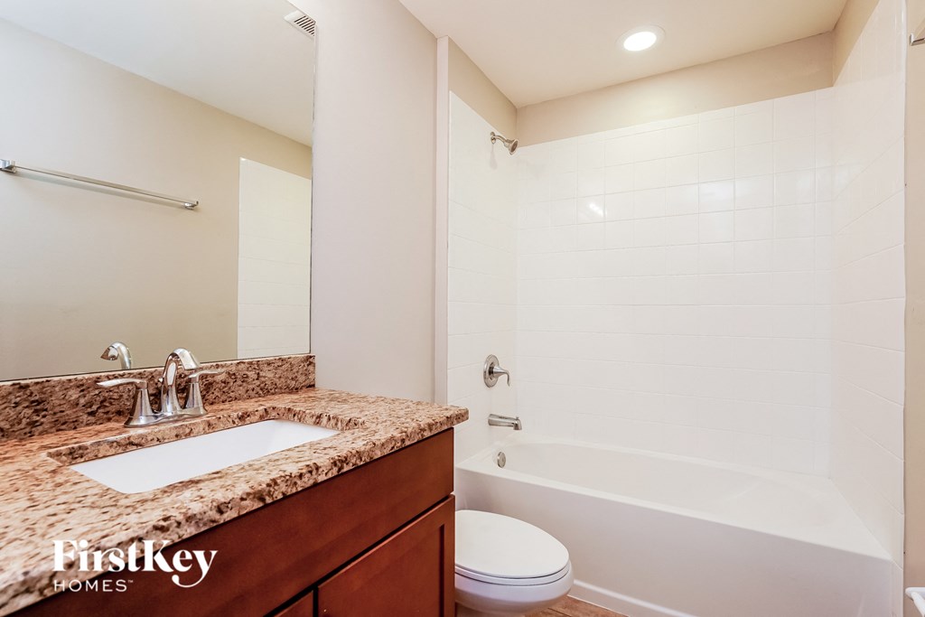 A bathroom with a sink, toilet, and bathtub.