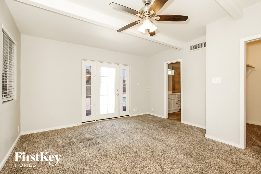 a living room with carpet and a ceiling fan