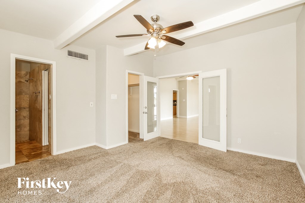 a living room with white walls and a ceiling fan