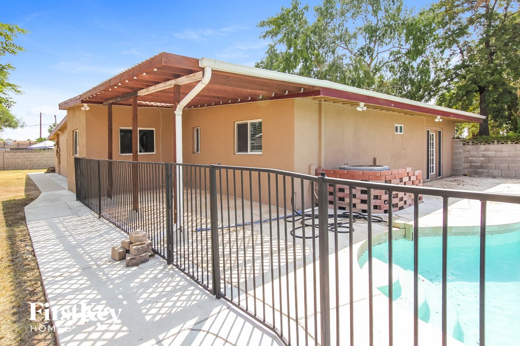 a backyard with a pool and a house with a fence