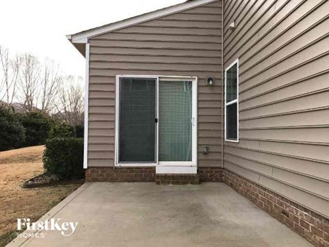 A house with a brown siding and a glass door is for sale.
