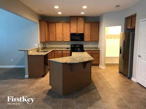 A kitchen with brown cabinets and a granite countertop.