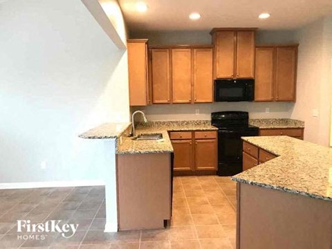 A kitchen with brown cabinets and granite countertops.