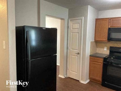 a kitchen with a black refrigerator and an open door