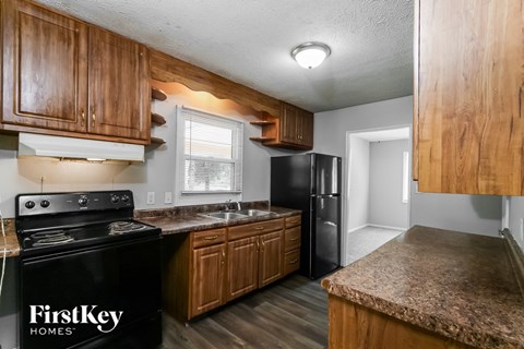A kitchen with wooden cabinets and a black stove top.