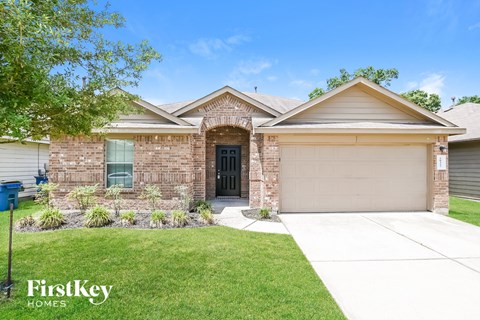A brick house with a garage door and a sign that says "FirstKey Homes".