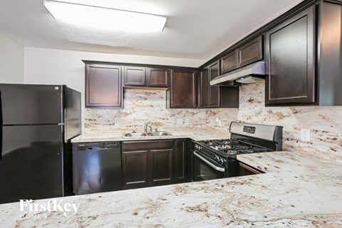 A kitchen with black cabinets and a dirty counter top.